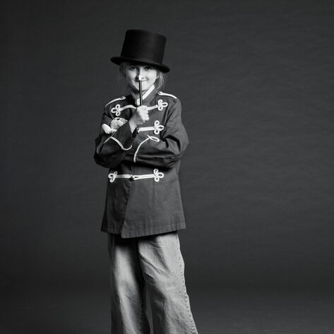 Ava mit Zylinder und Kostüm, in der Hand einen Stab